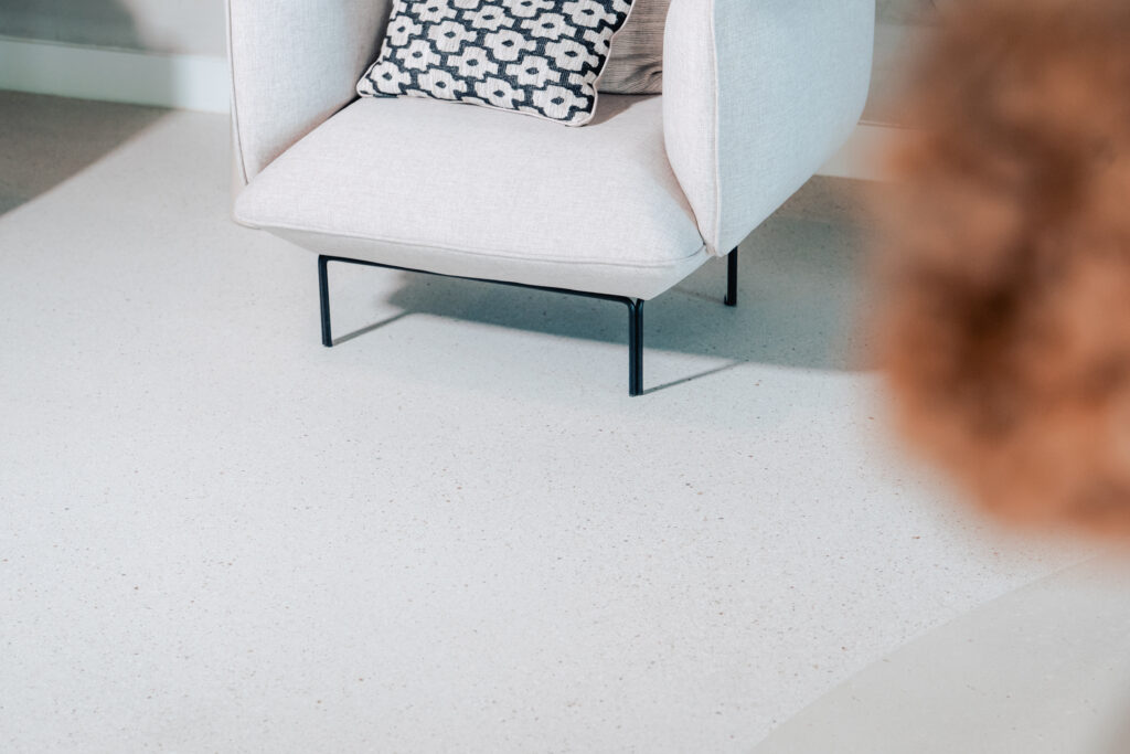 alt="Lichte microstone vloer in moderne woonkamer"
